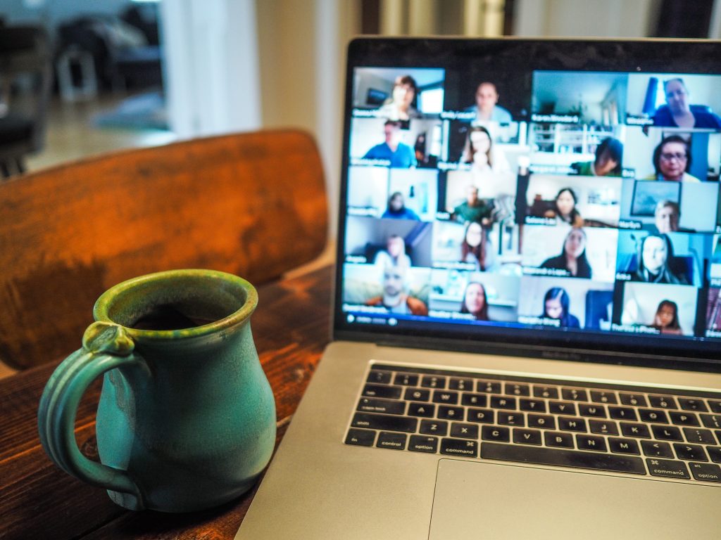 Tasse neben Laptop, auf dem Videokonferenz stattfindet